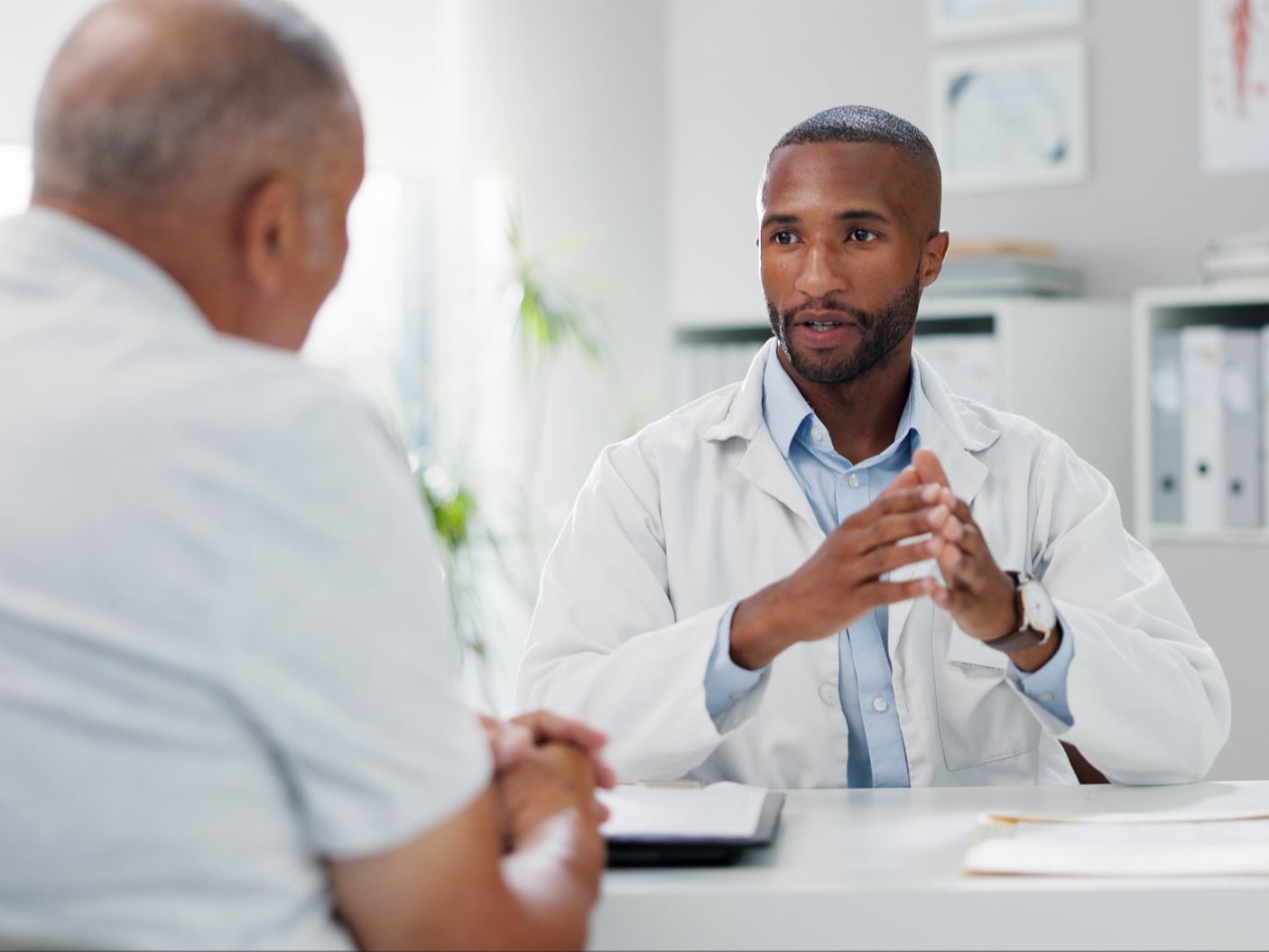 Doctor speaking with patient with PDA in hand.