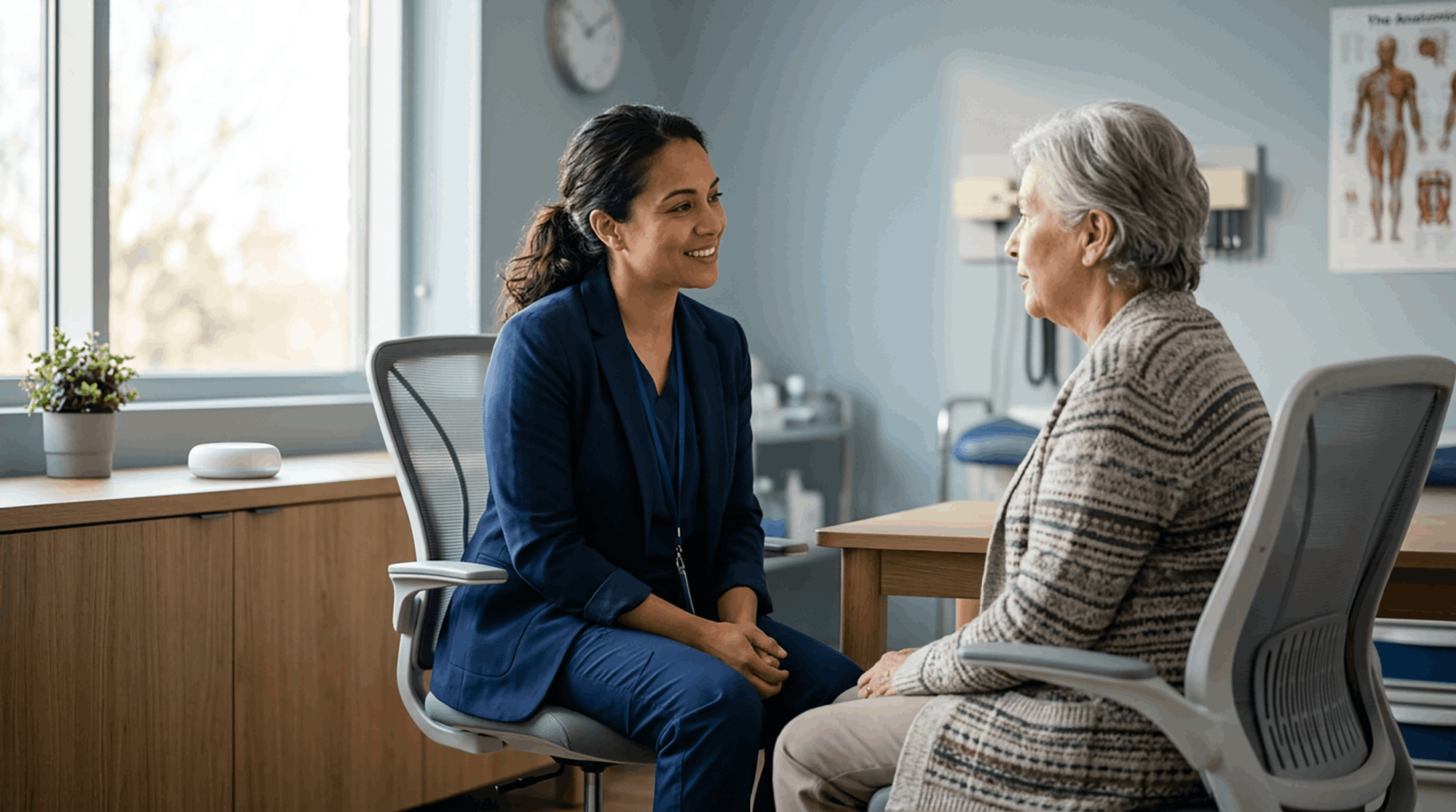 A physician discusses health conditions with her patient while an ambient AI device listens passively with the patient's permission, organizing and creating documentation for the patient's chart, allowing the provider face-to-face time and fewer documentation hours